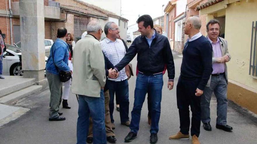 Luis Tudanca, en el centro, junto al alcalde coresino, José Luis Salgado, ayer por las calles del pueblo.