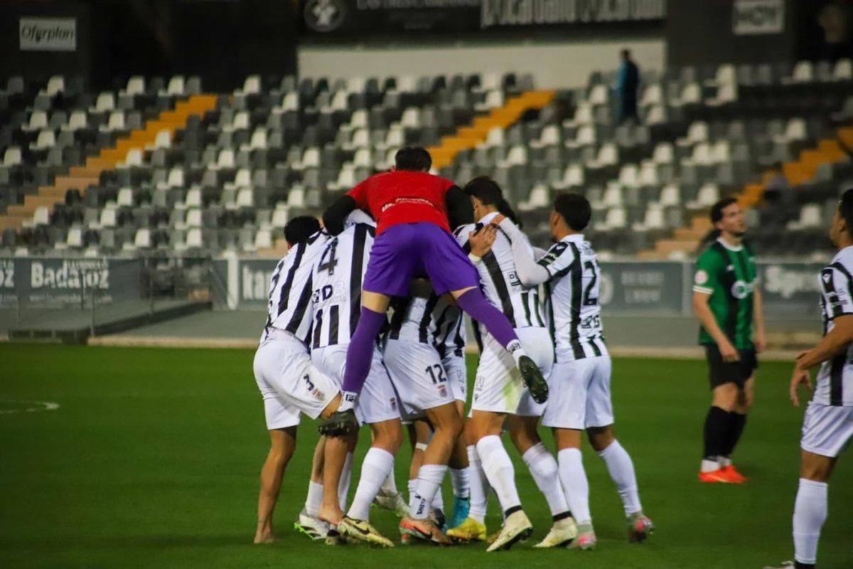 Los jugadores del Badajoz abrazan a Carlos Bravo tras anotar el gol de la victoria.