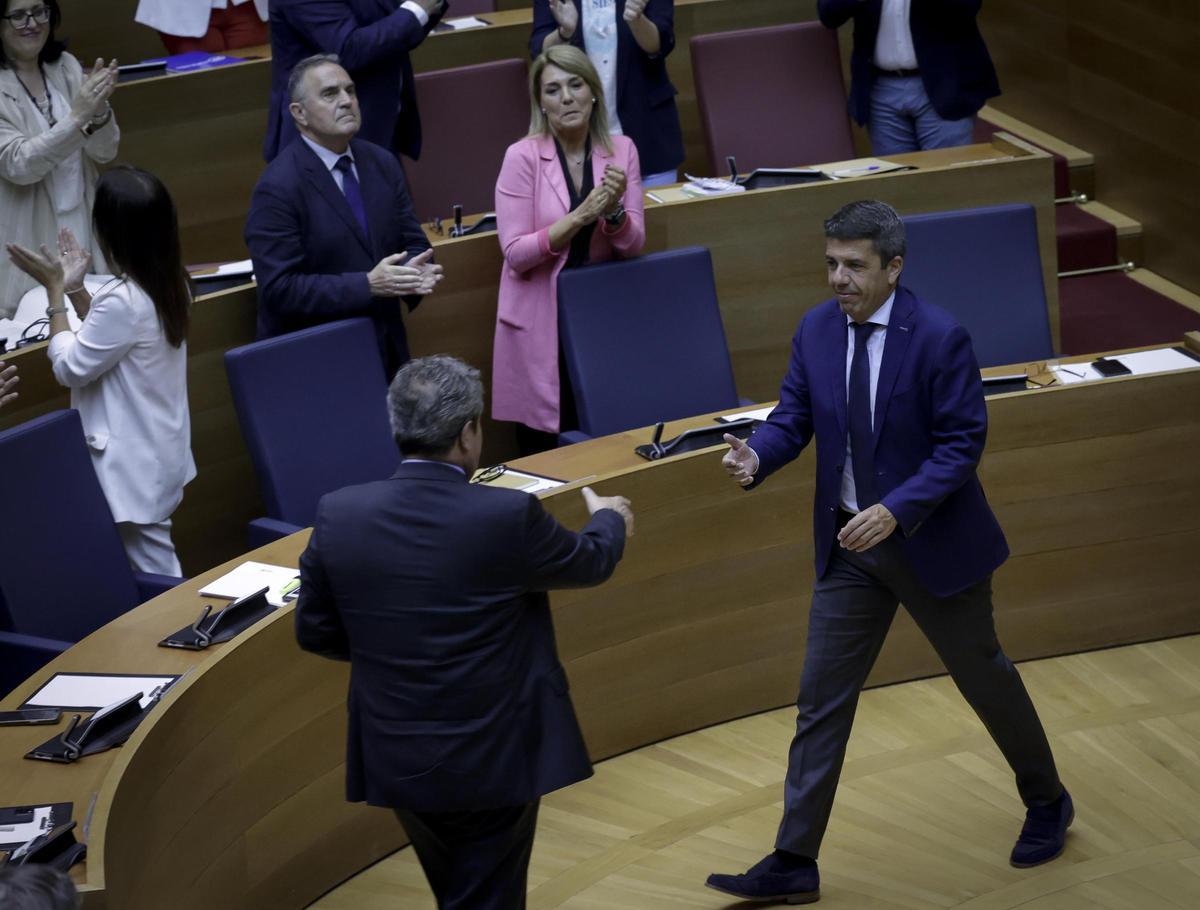 Mazón saluda a Llanos tras aprobar los presupuestos en las Corts.