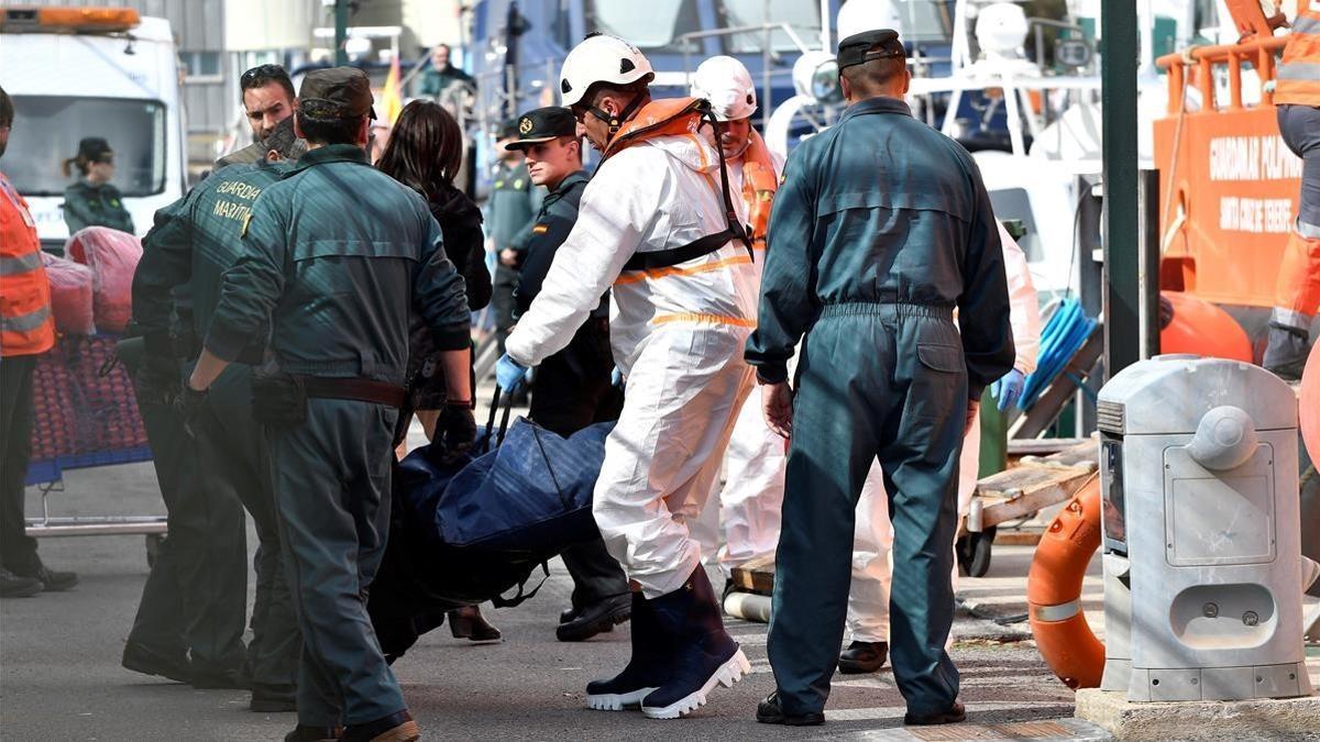 Miembros de Salvamento Maritimo y Guardia Civil trasladan  al puerto de Almeria  los cadaveres de tres varones que viajaban en una de las dos pateras rescatadas