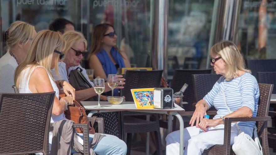 Varias turistas disfrutan del sol en una terraza de Alicante