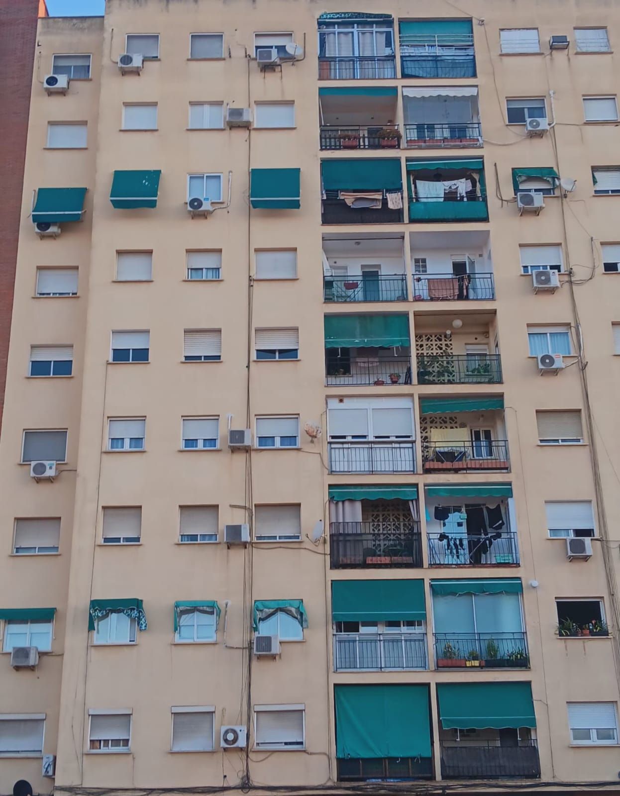 Un bloque de pisos con toldos verdes.