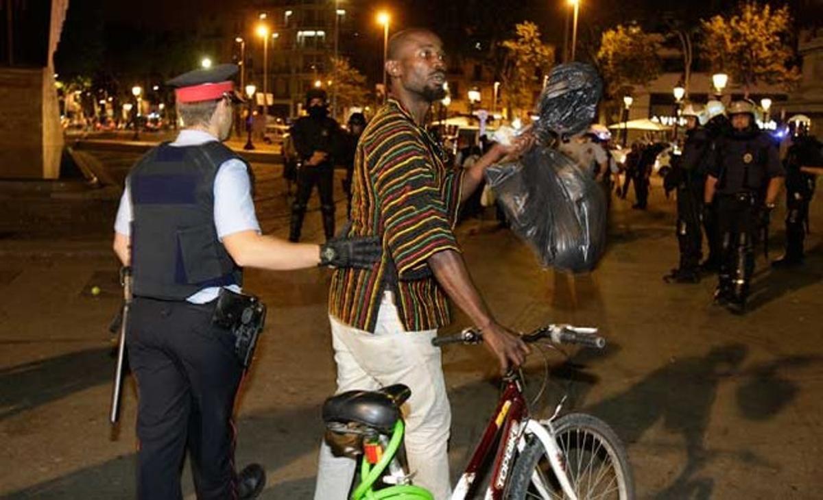 Un mosso acompanya un manifestant fora de la plaça durant el desallotjament de dijous a la matinada.