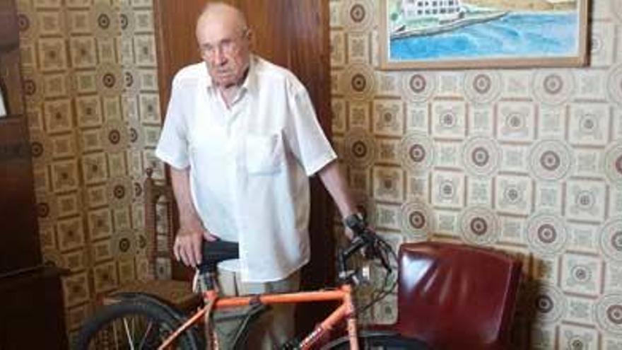 Vicent Tur posa junto a su bicicleta en el salón de su casa.