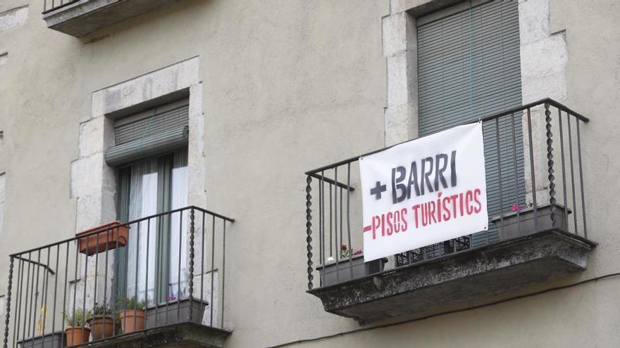 Imatge d&#039;un cartell que denuncia la proliferació dels allotjaments turístics a Girona