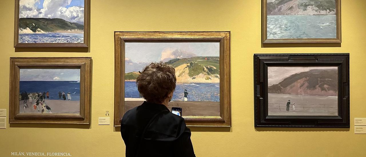 Una mujer observa cuadros de la exposición 'Sorolla. Viajar para pintar'.