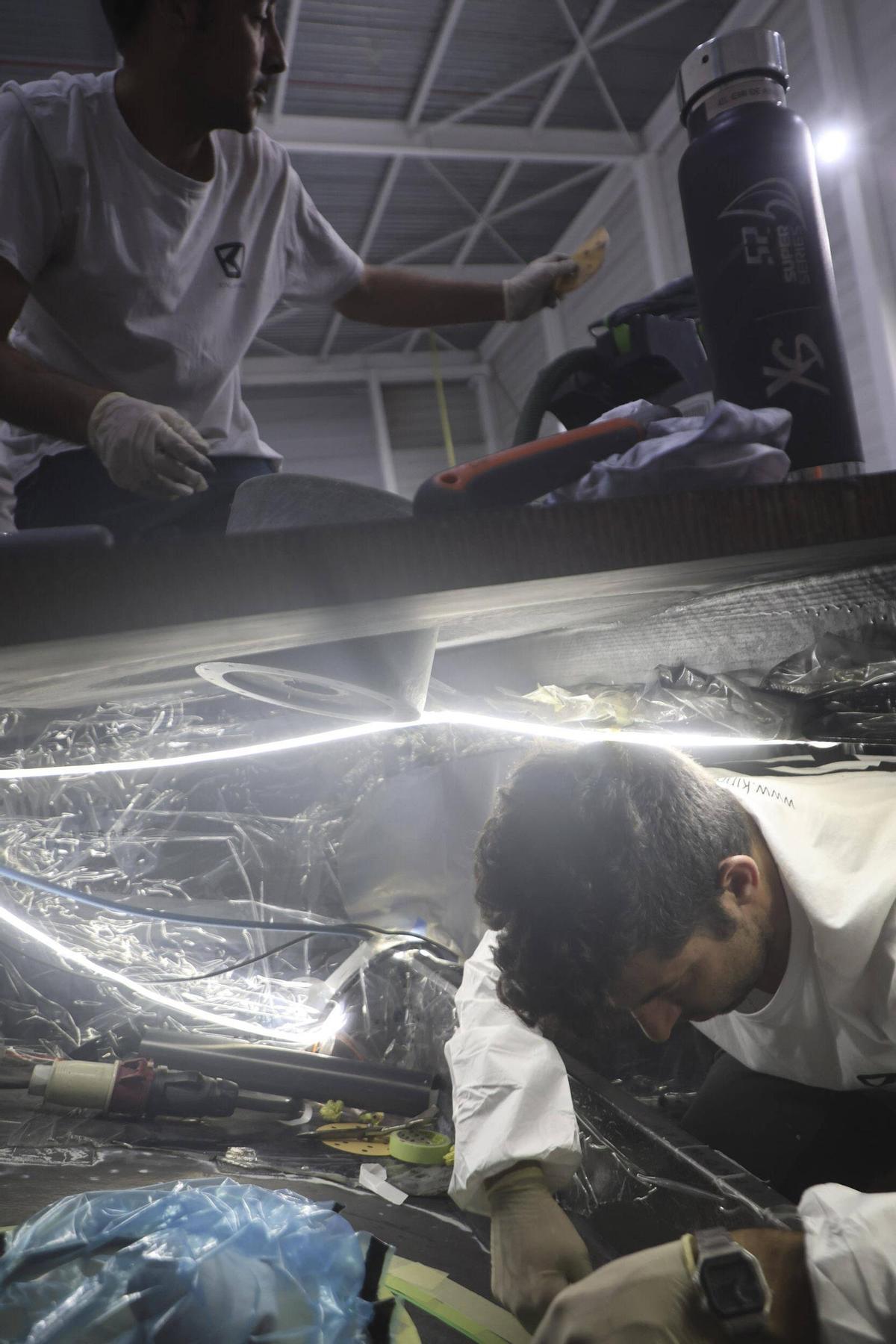 Dos trabajadores, en el exterior e interior de un barco de King Marine.