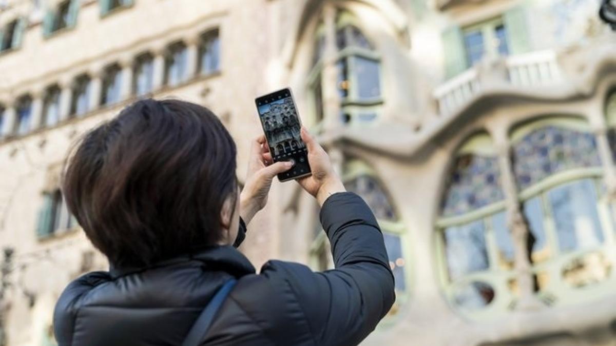 Una turista fotografía la Casa Batlló de Barcelona.