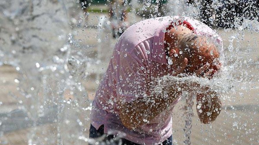 Un hombre se refresca en unas fuentes del parque de Abandoibarra en Bilbao durante una jornada marcada por las altas temperaturas provocadas por la ola de calor que recorre la península.
