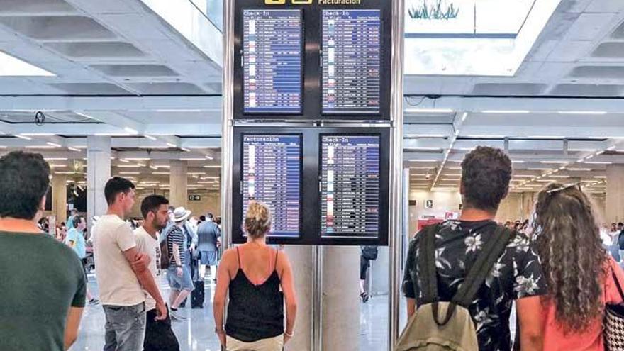 Pasajeros observan los paneles de información del aeropuerto de Son Sant Joan, en una imagen de archivo.