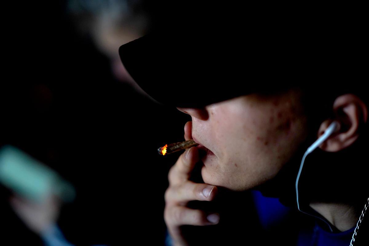 Un adolescente fuma un porro en su casa, en Madrid.