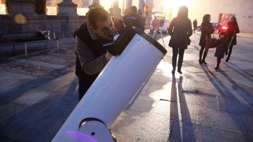 Un hombre observa el cielo con un telescopio.