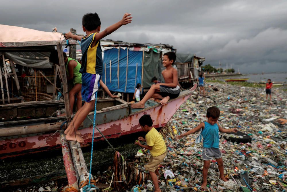 Niños juegan en un barco varado sobre la costa, llena de basura, de la playa Baseco en Manila, Filipins. REUTERS/Eloisa Lopez