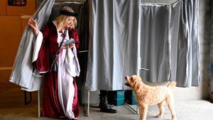 Una mujer con una túnica medieval sale de una cabina de votación en un colegio electoral francés, este domingo.