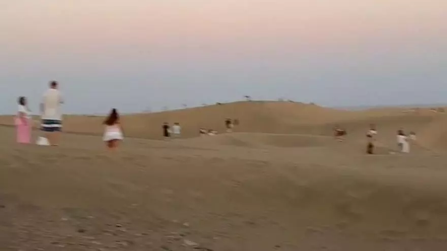 Una multitud entra en una zona prohibida de las Dunas de Maspalomas