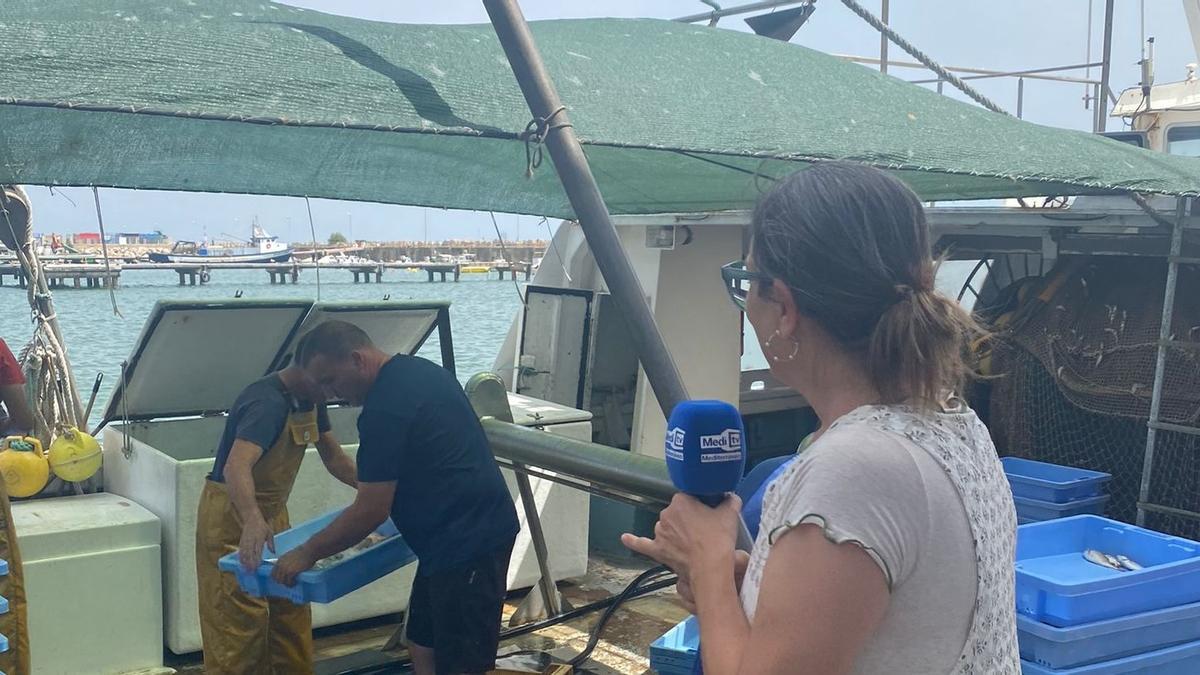 La conductora del programa, junto a un barco que llega a puerto.