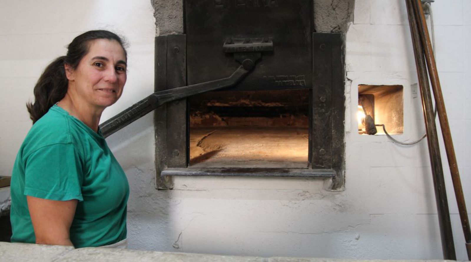 Isabel Coll vor dem mit Holz befeuerten Ofen in der Bäckerei Can Caragol.
