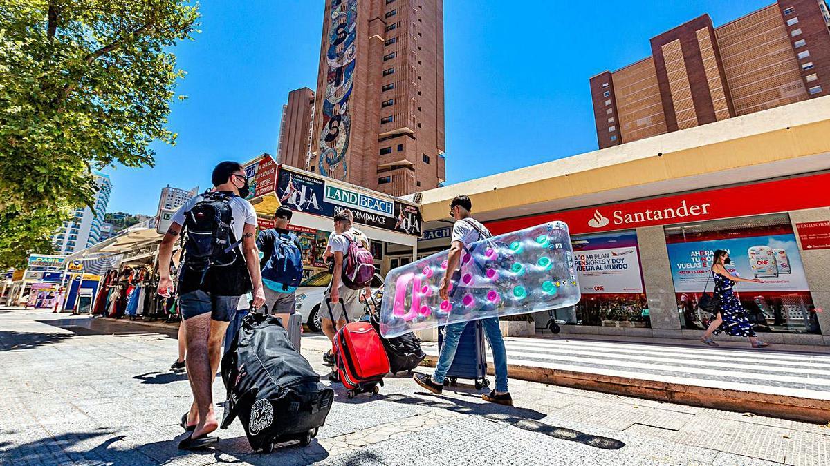 Un grupo de jóvenes, cargados con maletas, para pasar sus vacaciones en Benidorm.  | DAVID REVENGA