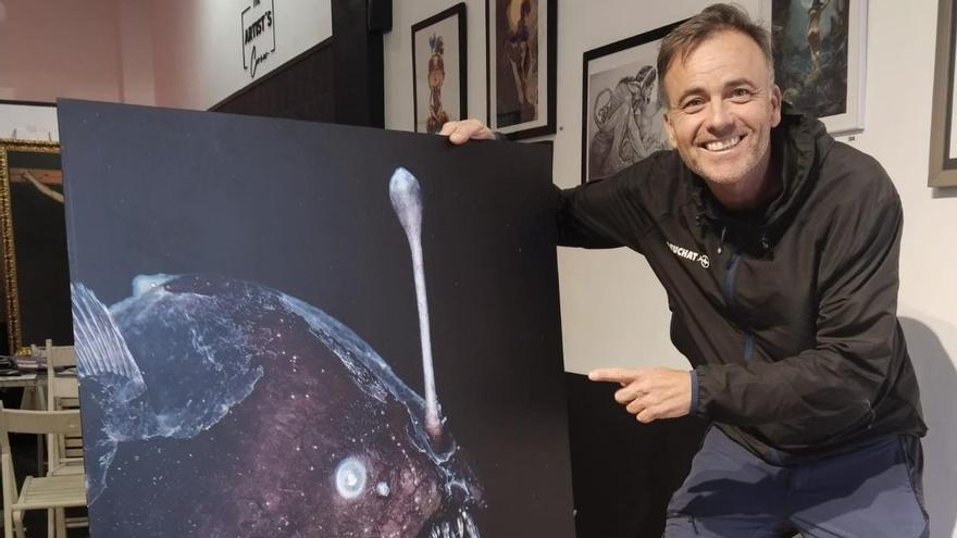 Juan Carballo posa con una reproducción de su fotografía.