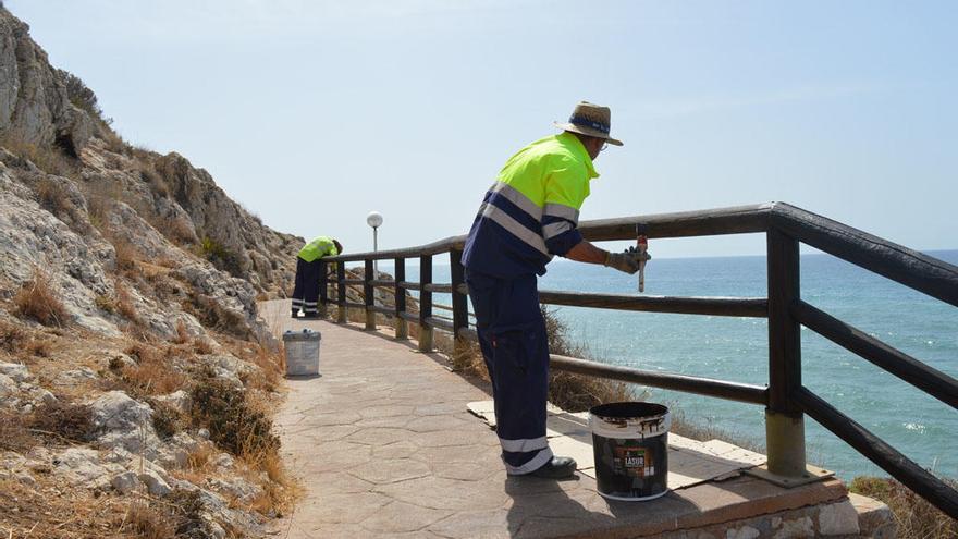 Operarios pintando las barandillas de la Senda Litoral en los acantilados de El Cantal.