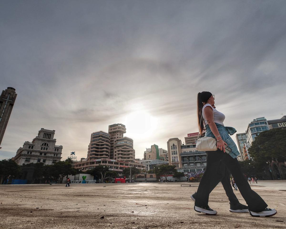 Una pareja camina ayer bajo el sol por el lago de la plaza de España de Santa Cruz.