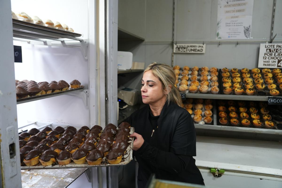 Sonsoles coloca una bandeja de magdalenas en el mostrador de la panadería de Carabanchel.