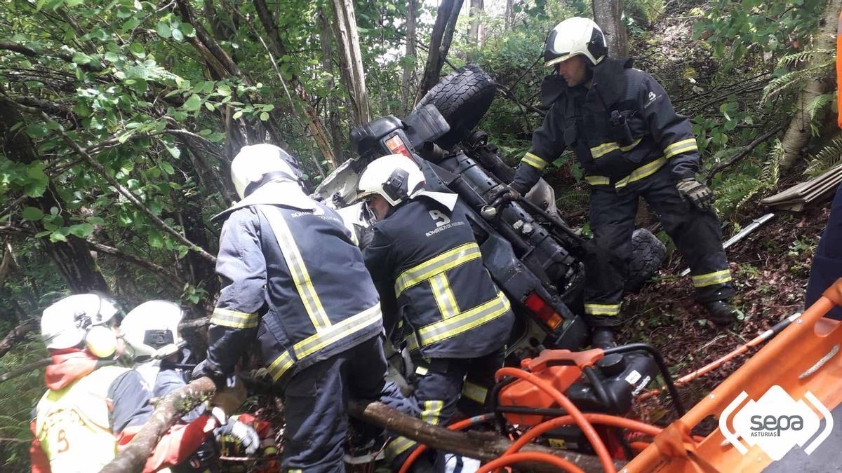 Los bomberos junto al coche accidentado.