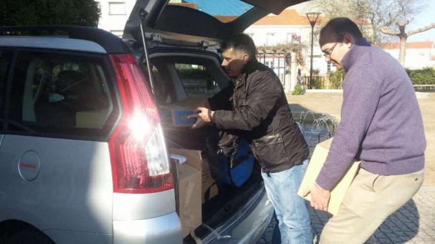 Alfredo Bea y Francisco Meis introducen en el coche el material que se llevaron a Monfragüe, ayer.