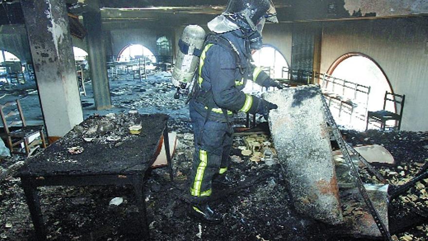 Un bombero inspecciona la planta, que quedó calcinada por el incendio, tras extinguir las llamas.