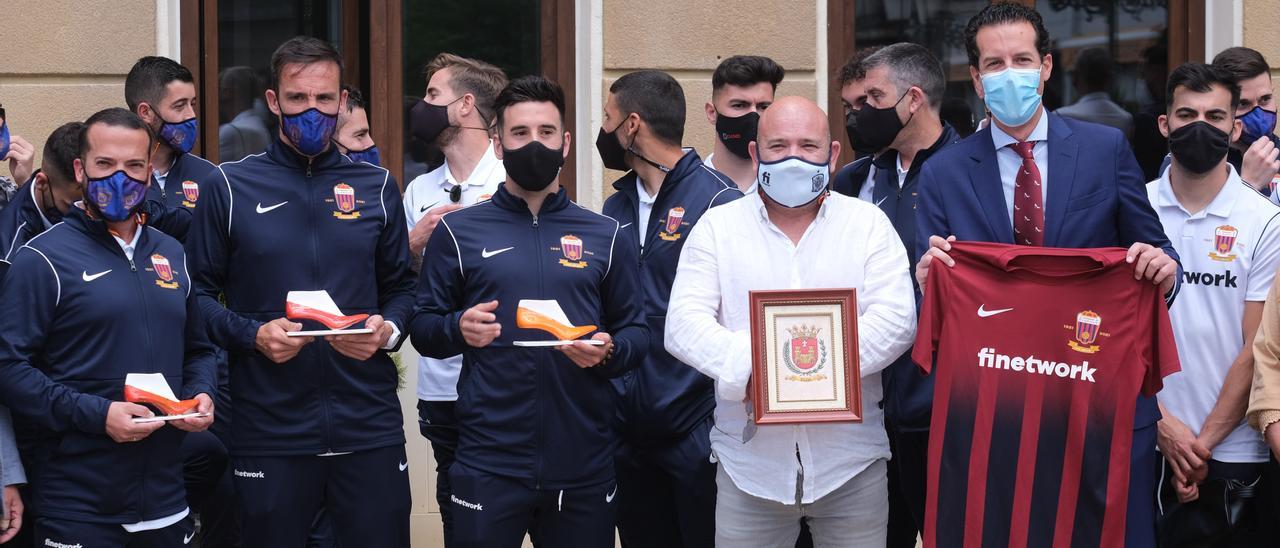 El alcalde con la camiseta del Deportivo Eldense y el presidente del club con un cuadro del escudo de la ciudad.