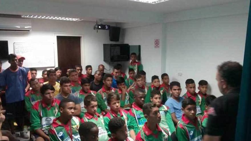 Vidales, a la derecha, da una charla a los niños de la Academia Puerto Cabello, vestidos con camisetas del Arenal.