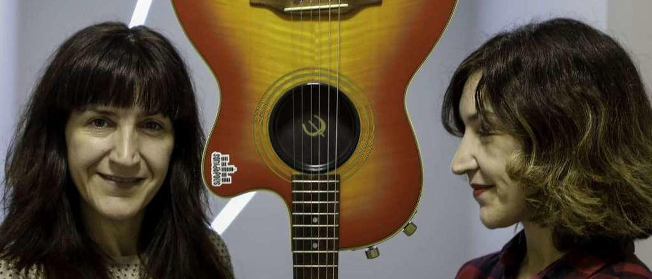 Las hermanas Mar y Alicia Álvarez posan con una guitarra en la escuela de música &quot;Sonidópolis&quot;, en la que trabaja Mar.