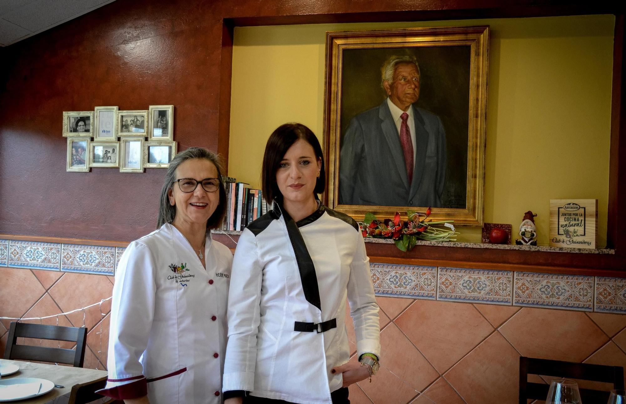 Herminia Nuevo y su sobrina nieta Macarena García, posan ante el retrato del padre de Herminia y fundador de este restaurante, José Nuevo.