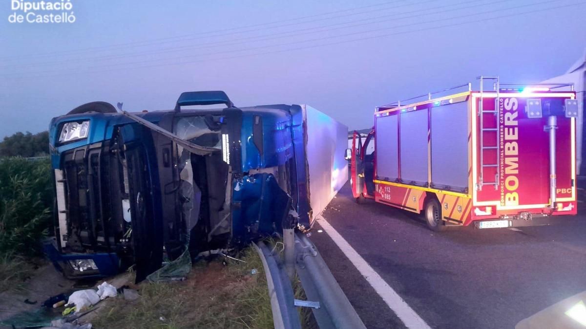 El camión accidentado en Torreblanca junto al vehículo de los bomberos que ha acudido al rescate este jueves.