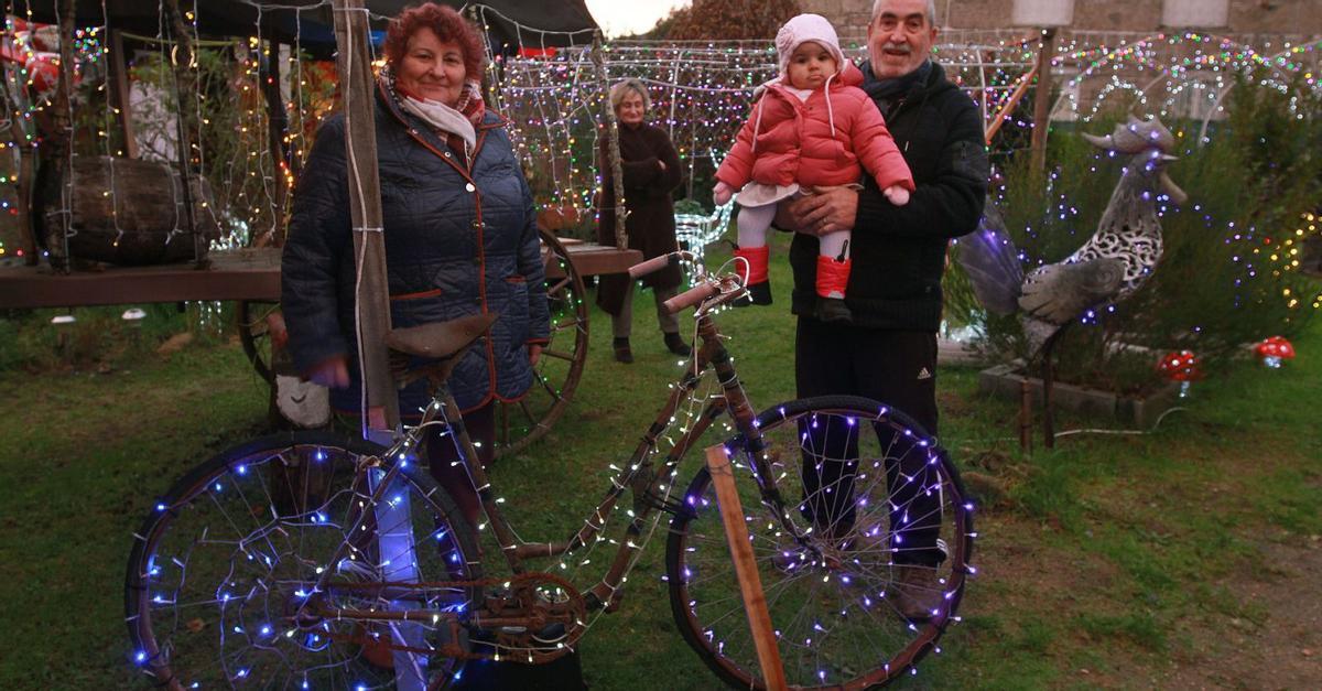 Isabel y Pepe, con su nieta, en uno de los rincones de los 800 metros de su particular parque temático navideño de Loeda. |   // IÑAKI OSORIO