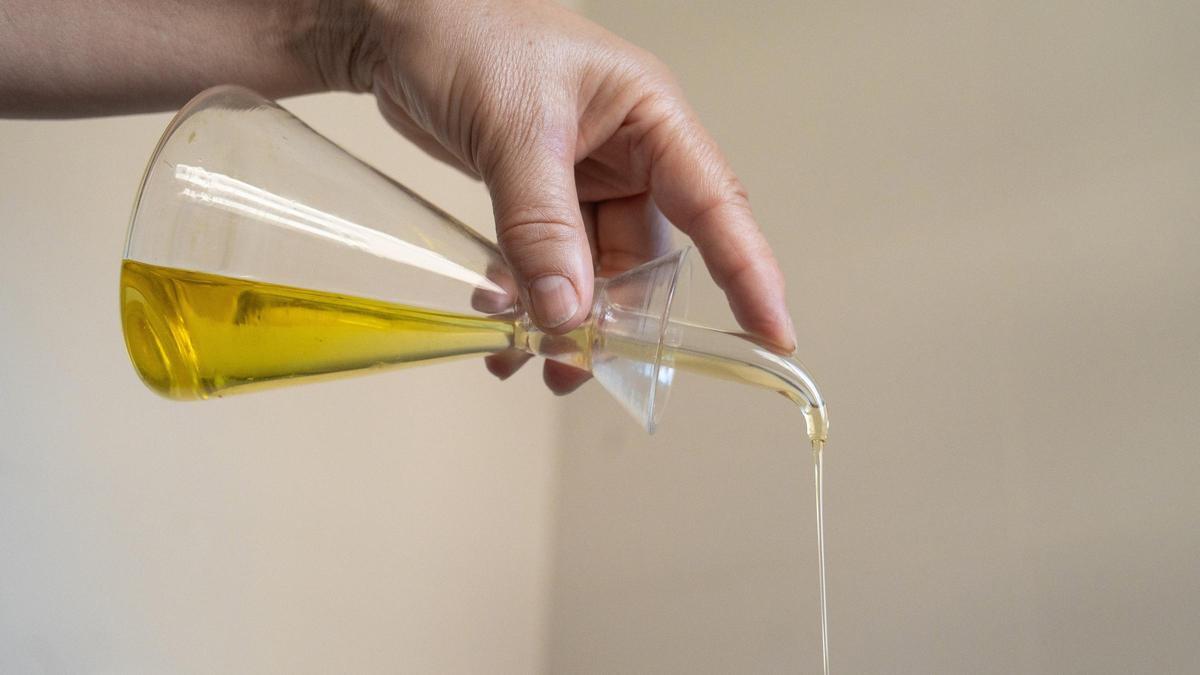 Una persona echa aceite de una aceitera.