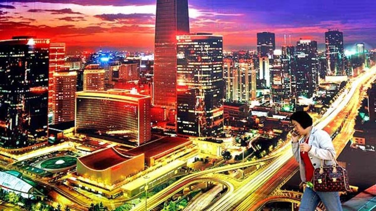 Una dona passa davant un pòster del districte financer de Pequín.