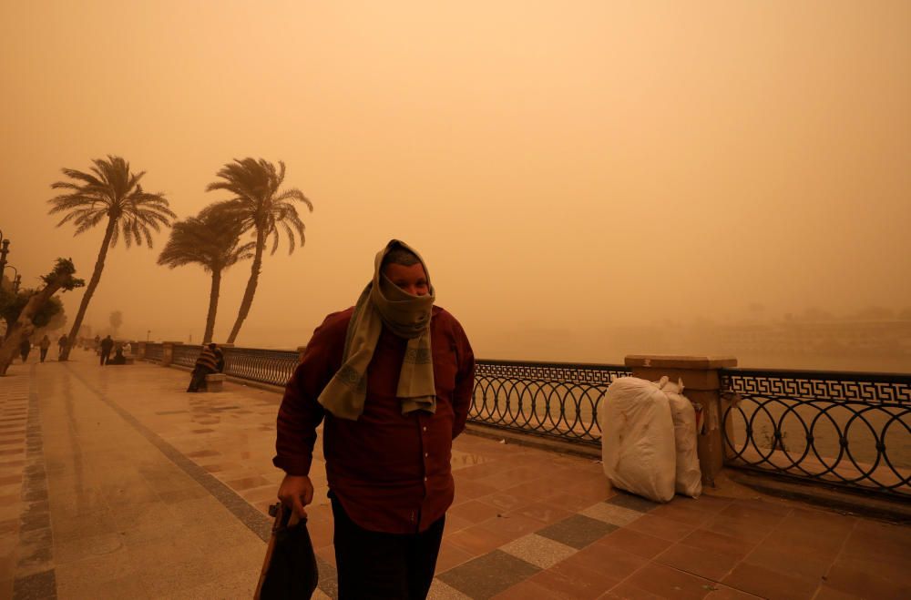 A man covers his face during a sandstorm near ...