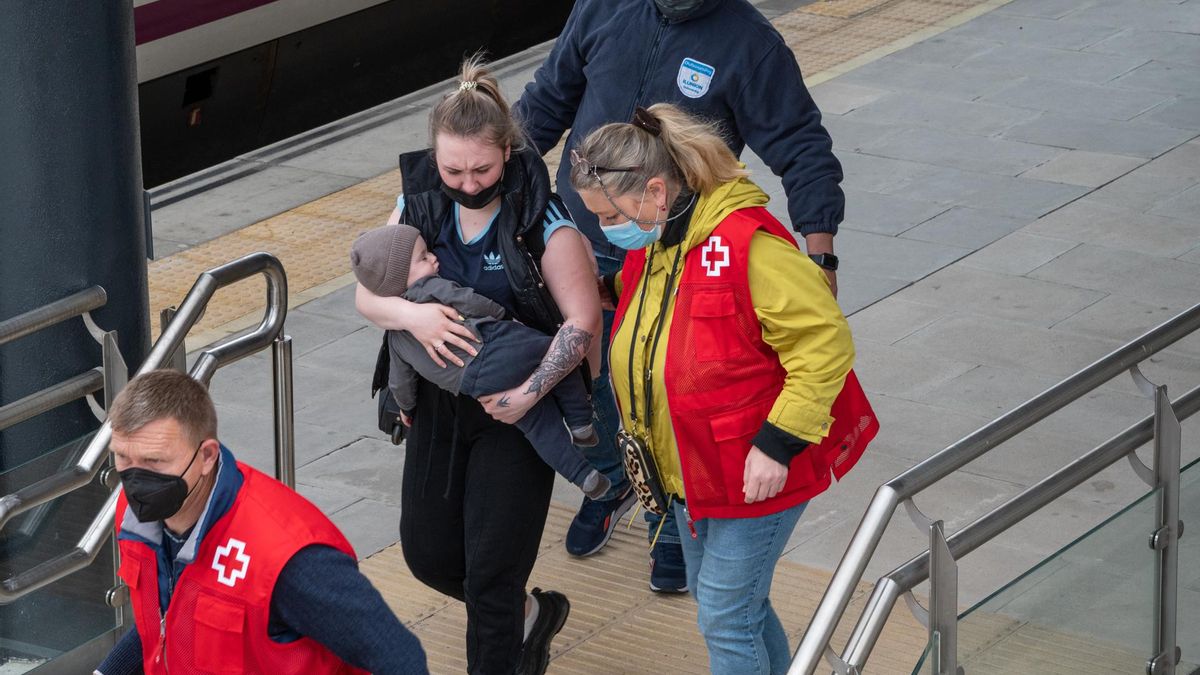 Yrina acompaña a una joven madre con un bebé en el andén de la estación de trenes de Badajoz este lunes.
