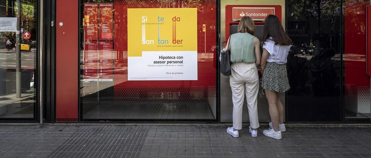 Dos mujeres retiran dinero de un cajero