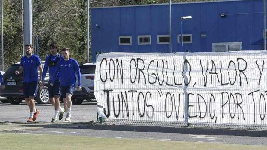 Johannesson, Toché, Carlos Martínez y Viti, a la salida al campo con las pancartas de apoyo de fondo.