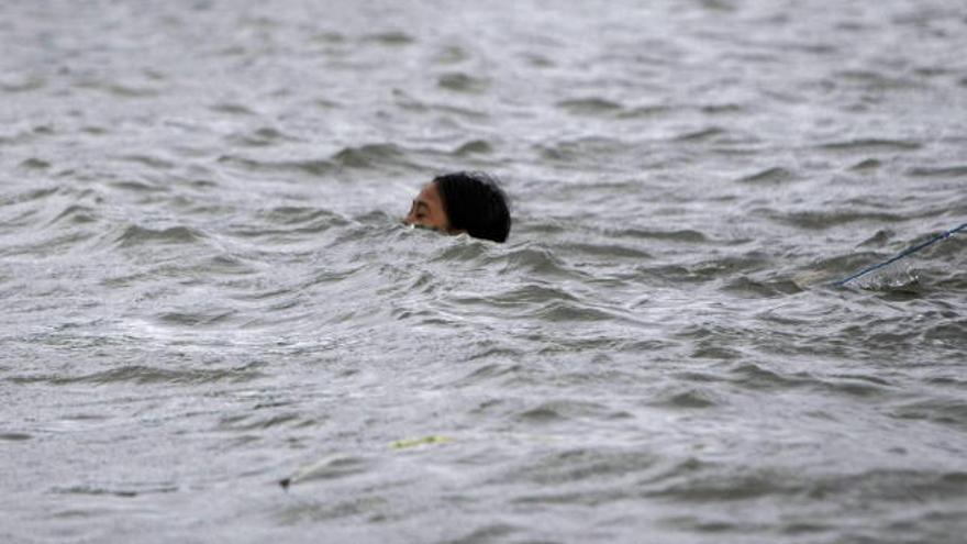 Un filipino atraviesa el agua de las inundaciones nadando en Malabon.