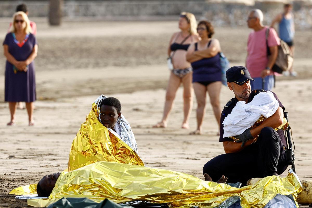 La llegada de un cayuco con 66 migrantes a la playa de Las Burras en Gran Canaria, en imágenes. La embarcación ha alcanzado el arenal por sus propios medios con unos 66 migrantes a bordo, entre ellos un bebé ante la mirada de bañistas.
