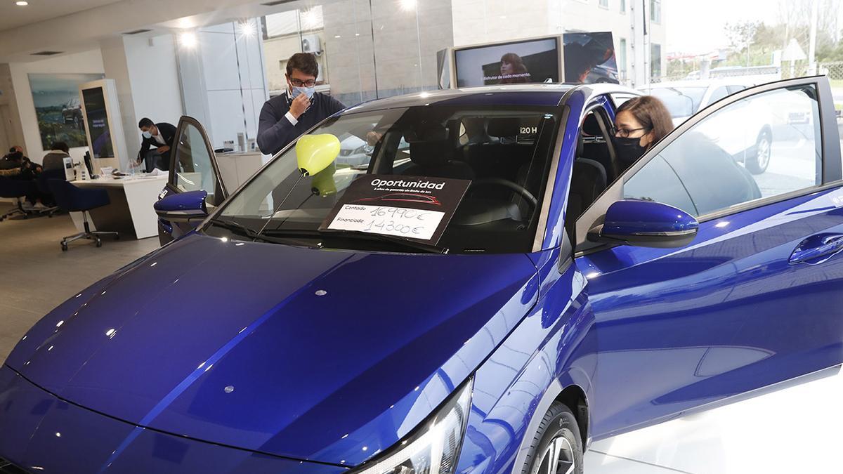 Dos personas viendo un coche en un concecionario vigués.