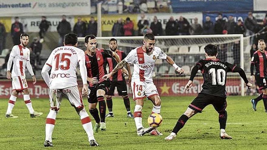 Dani Rodríguez trata de dar un pase ante la atenta mirada de un defensor del Reus.