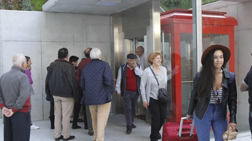 Los primeros usuarios del ascensor urbano salen de la cabina. // Adrián Irago