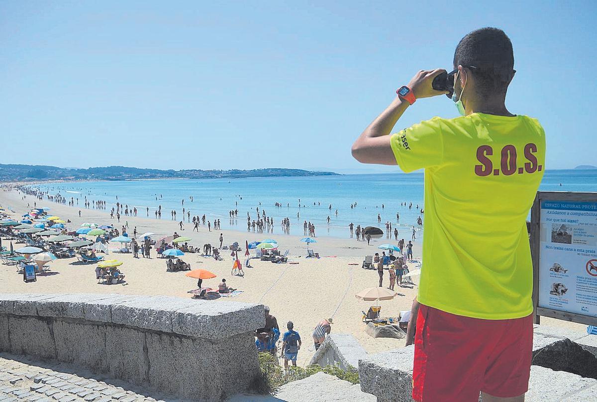 Un socorrista vigila a los bañistas en la playa de A Lanzada, en O Grove /