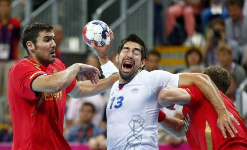 Spain's Eduardo Gurbindo Martinez tries to block France's Nikola Karabatic as he attempts to score in their men's handball quarterfinals match in London