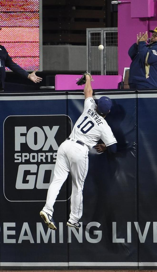 Hunter Renfroe, Nº 10 de los Padres de San Diego, no puede lograr un gran home run con Jesse Winker Nº 33 de los Rojos de Cincinnati durante la séptima entrada de un juego de béisbol en Petco Park.