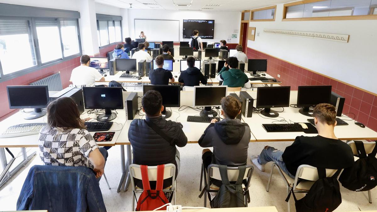 Estudiantado de Secundaria, en una aula de informática durante una clase frente a las pantallas de ordenador.